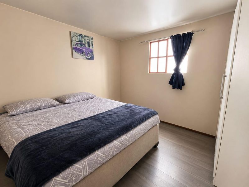 A well-maintained bedroom featuring modern laminate flooring and a built-in wardrobe, offering a clean and functional living space.