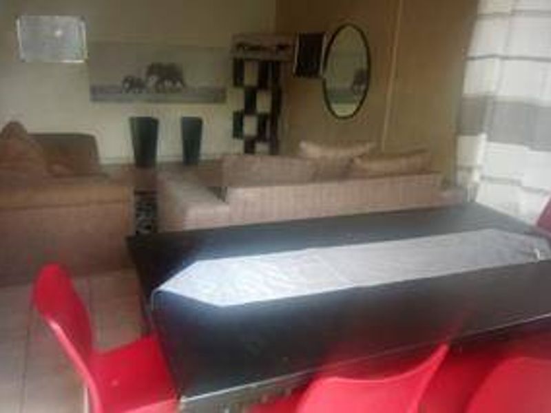 An open-plan living and dining area featuring tiled flooring, providing a functional space for relaxation and meals.