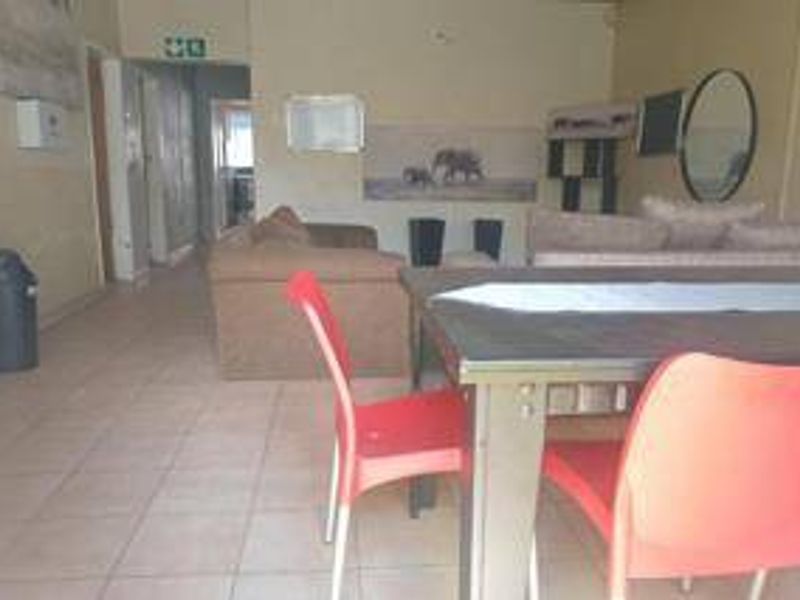 An open-plan living and dining area featuring tiled flooring, providing a functional space for relaxation and meals.