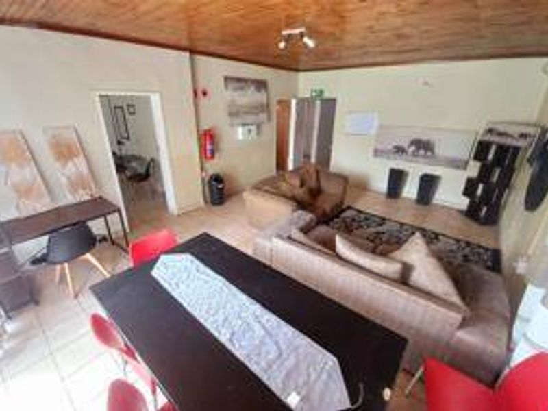 Open-plan living and dining area featuring tiled flooring and a timber-paneled ceiling, offering a functional layout for family living.