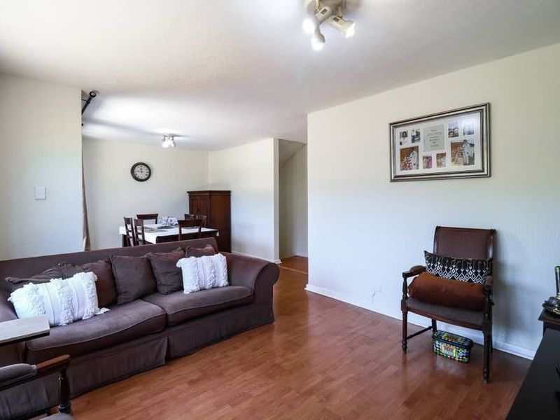 Open plan living and dining area featuring laminate flooring and neutral wall finishes, providing a versatile space for relaxation and entertaining.