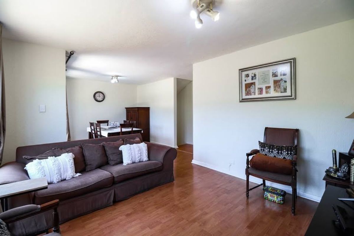 Open plan living and dining area featuring laminate flooring and neutral wall finishes, providing a versatile space for relaxation and entertaining.