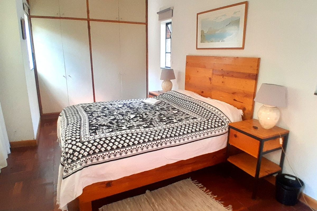 A bedroom featuring parquet flooring, built-in cupboards, and recessed ceiling lighting.