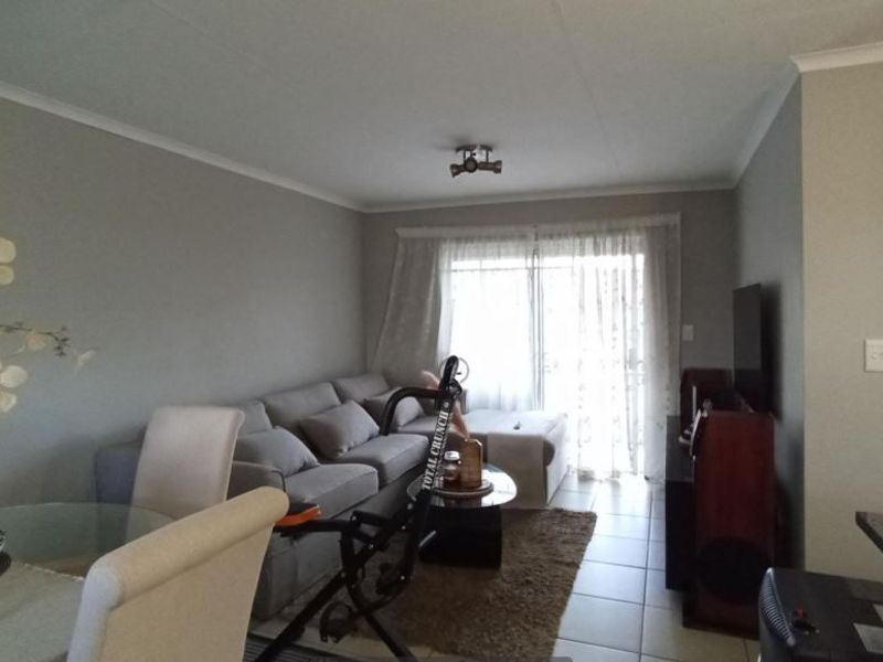 Open plan living and dining area featuring tiled flooring and a sliding glass door providing access to the exterior.