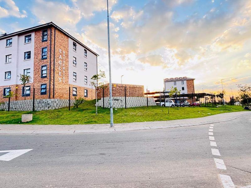 Exterior view of the apartment complex featuring brick facade construction, landscaped grounds, and perimeter fencing, captured from the street level.