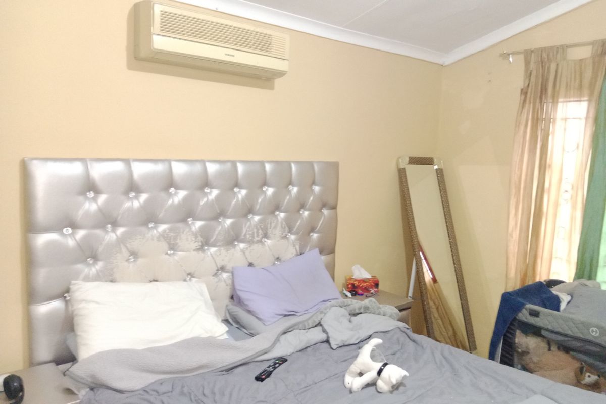 A bedroom featuring a wall-mounted split-system air conditioner and coving detail.