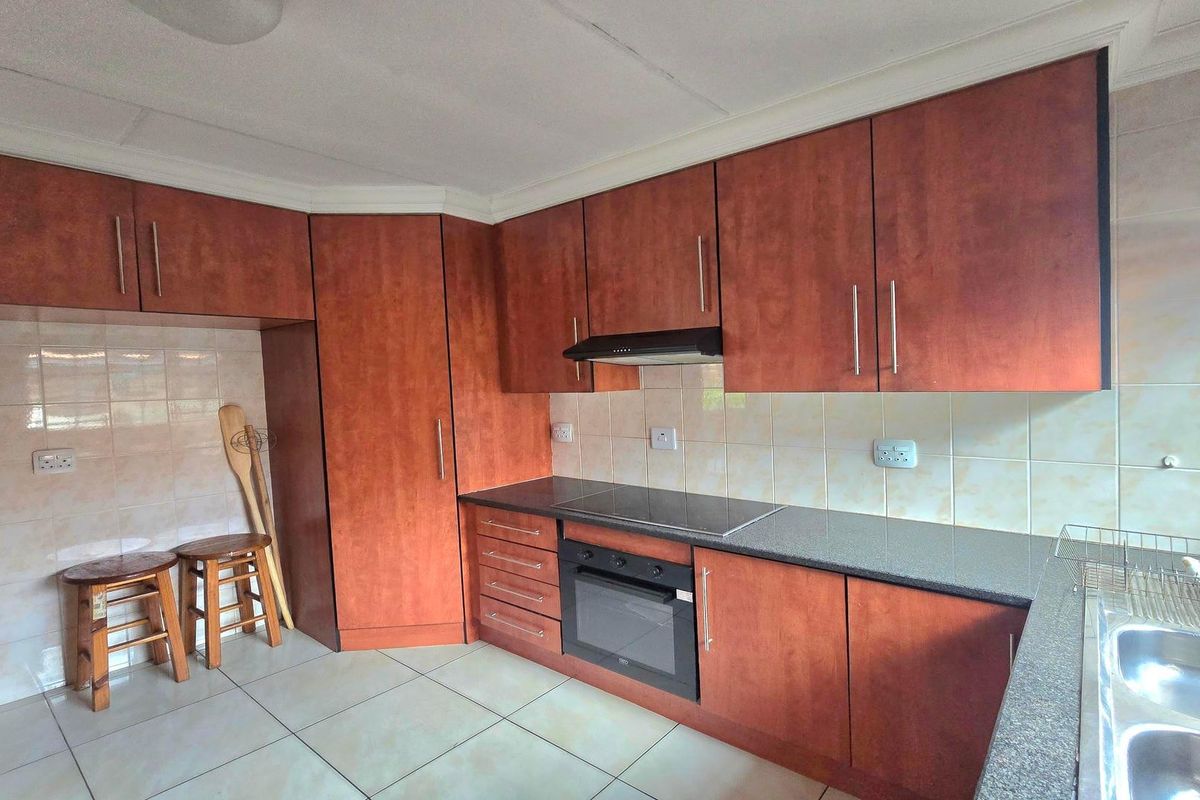 Functional kitchen featuring wood-tone cabinetry, granite countertops, ceramic tile backsplash, and integrated cooking appliances.