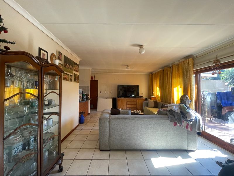 Open plan living area featuring ceramic floor tiles and large sliding glass doors providing access to the outdoor space.