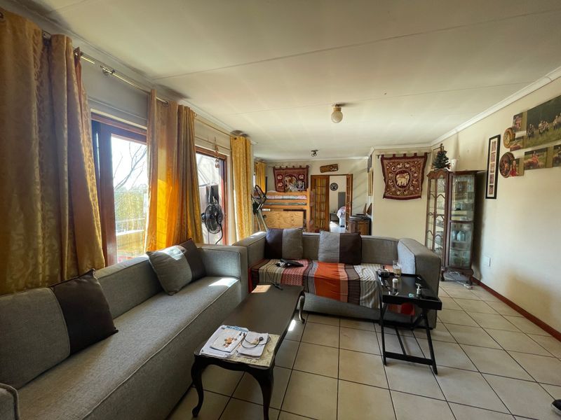 Spacious living room featuring tiled flooring and large sliding glass doors that provide natural light and access to the outdoor area.