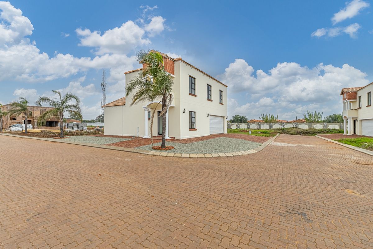 A modern two-story residential house featuring a paved driveway, integrated garage, and clean exterior finishes in a suburban estate setting.