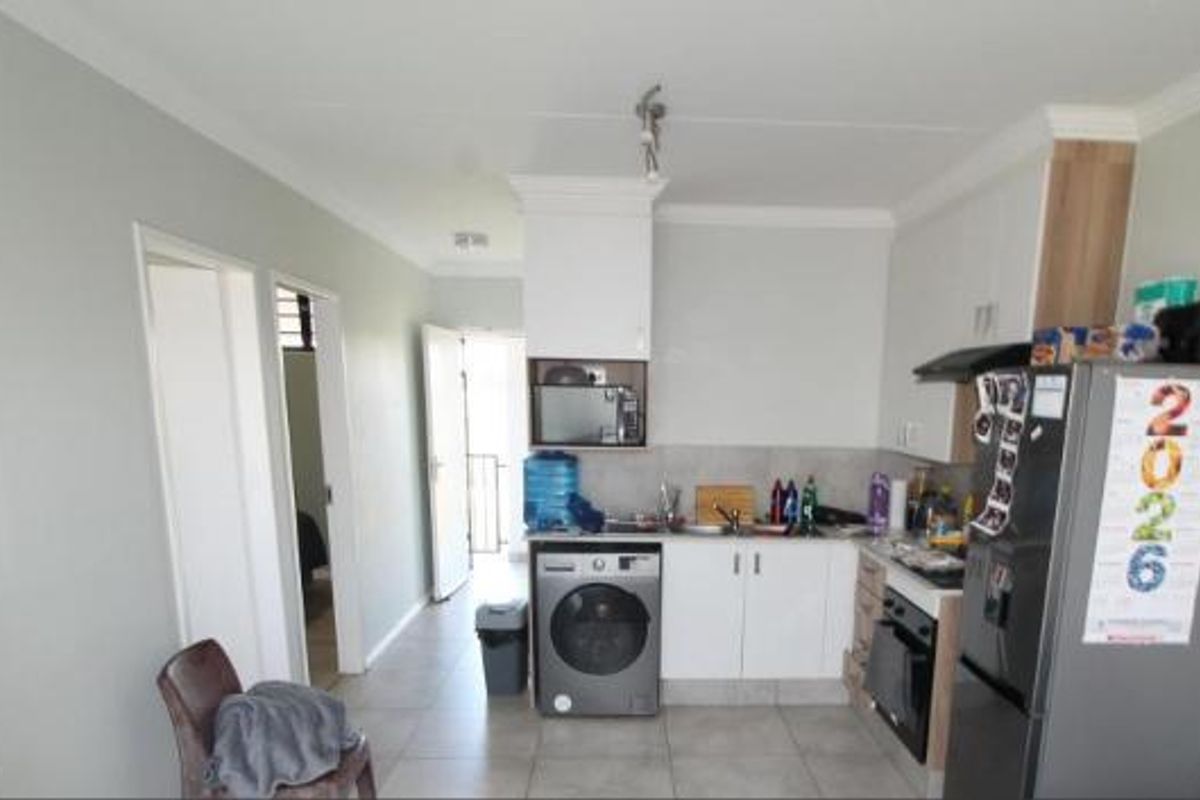 A functional kitchen featuring built-in cabinetry, integrated oven, extractor fan, and tiled flooring, providing a practical layout for daily meal preparation.