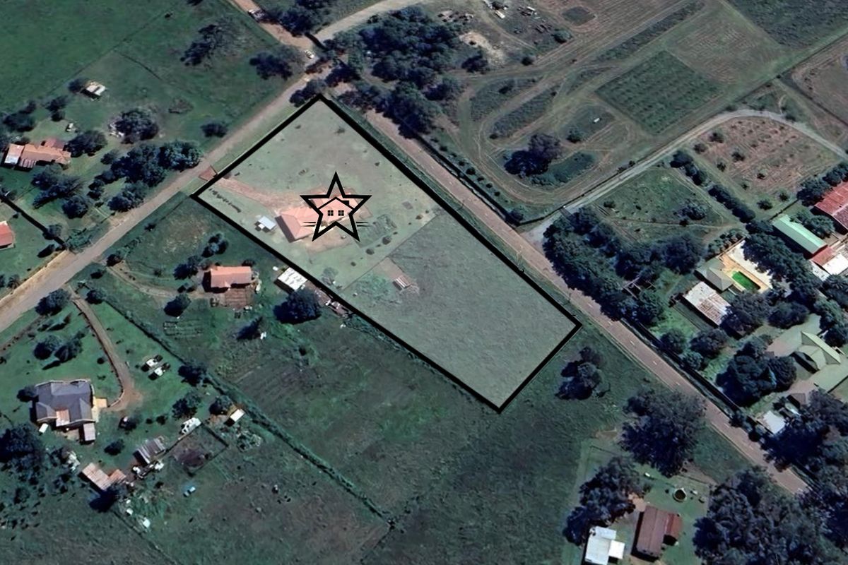 Aerial view of a large residential plot with a marked property location, showcasing the surrounding landscape and site boundaries.