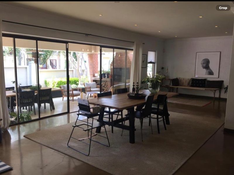 Spacious open-plan living and dining area featuring polished concrete floors and large sliding glass doors that open onto a covered patio.