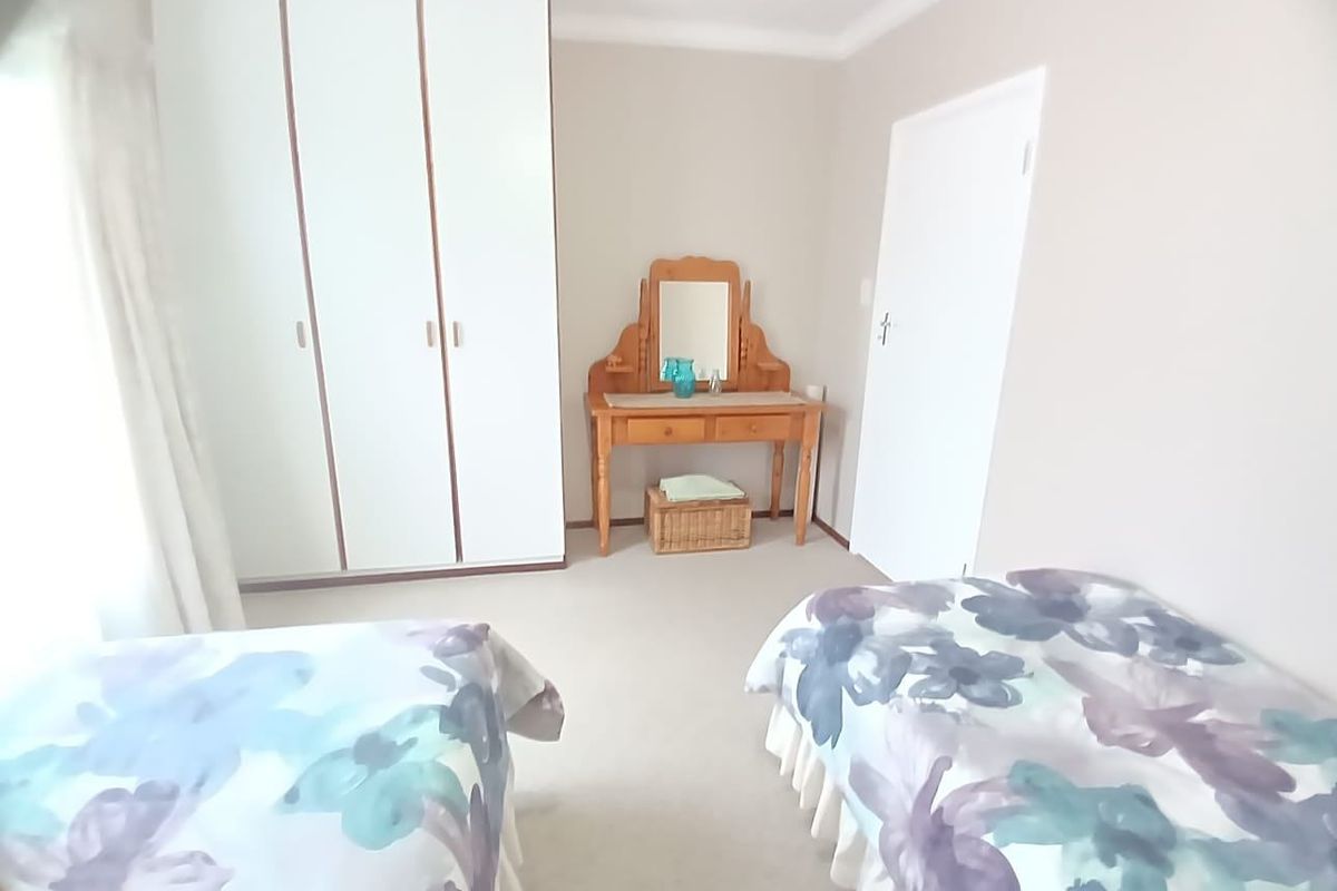 A bedroom featuring built-in cupboards, neutral wall finishes, and carpeted flooring.