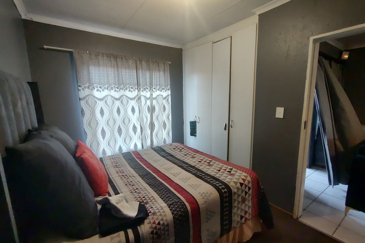 A functional bedroom featuring built-in cupboards and neutral wall finishes, providing a practical space with standard residential fixtures.