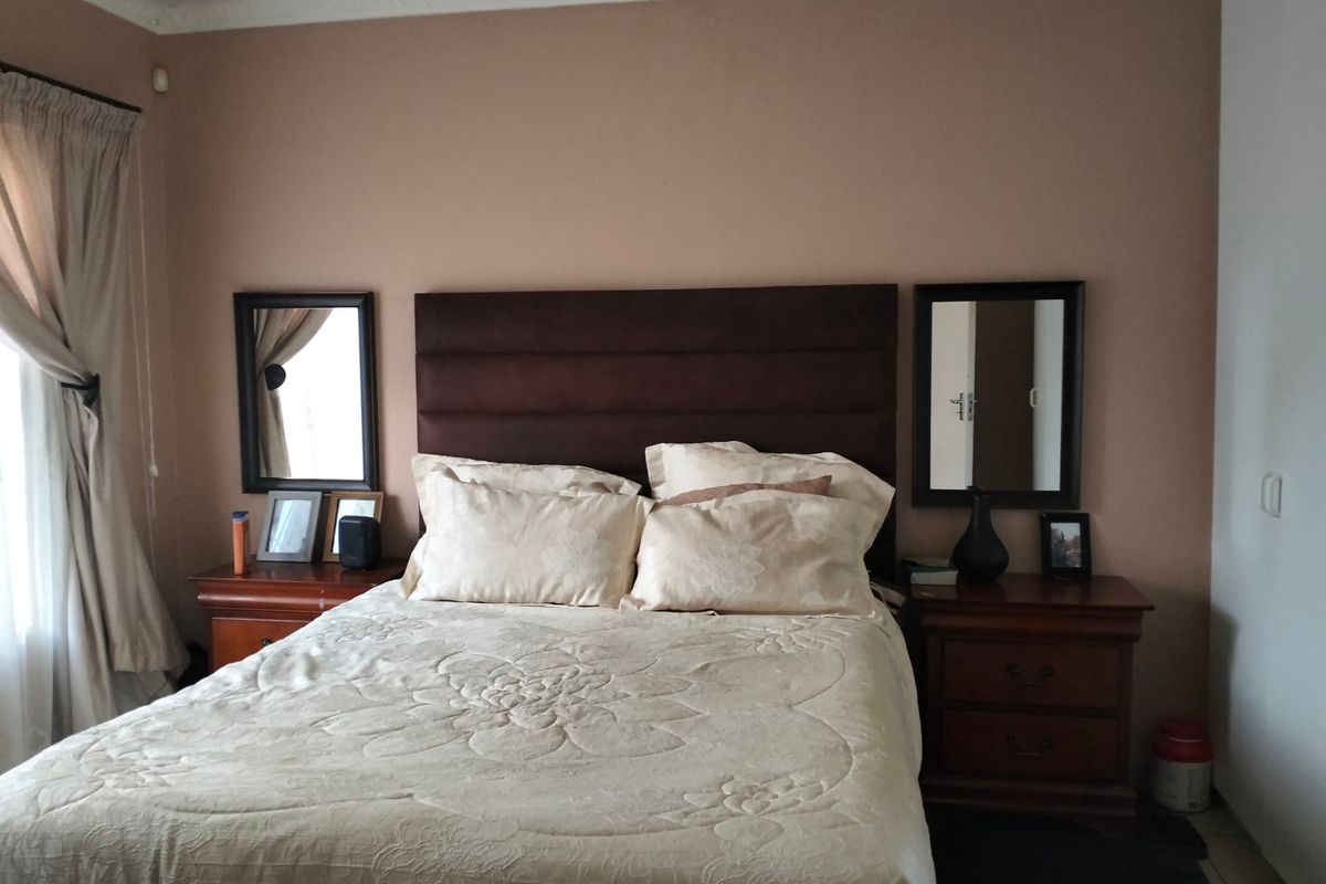 A bedroom featuring crown molding and a built-in headboard, providing a neutral foundation for interior design updates.