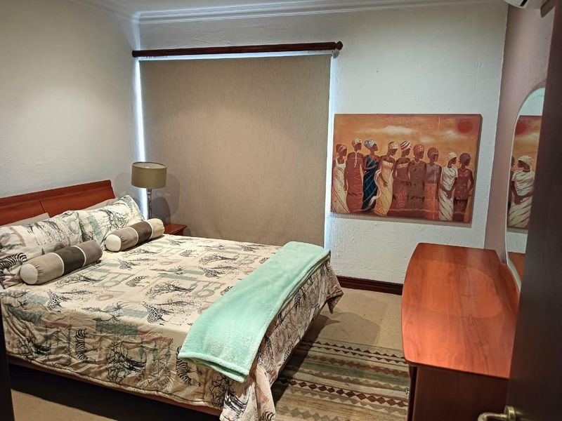 A cozy bedroom featuring a roller blind, coving, and an air conditioning unit, providing a comfortable and functional living space.