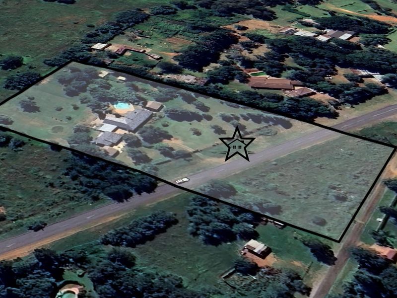 Aerial view of the property showing the large plot, main dwelling, swimming pool, and surrounding landscape.