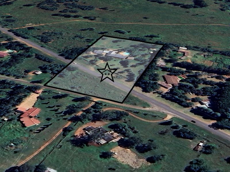 Aerial view of the property showing the land plot, main dwelling, swimming pool, and surrounding landscape.