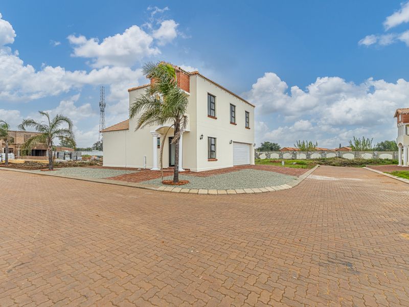 A modern two-story residential house featuring a paved driveway, integrated garage, and clean exterior finishes in a suburban estate setting.
