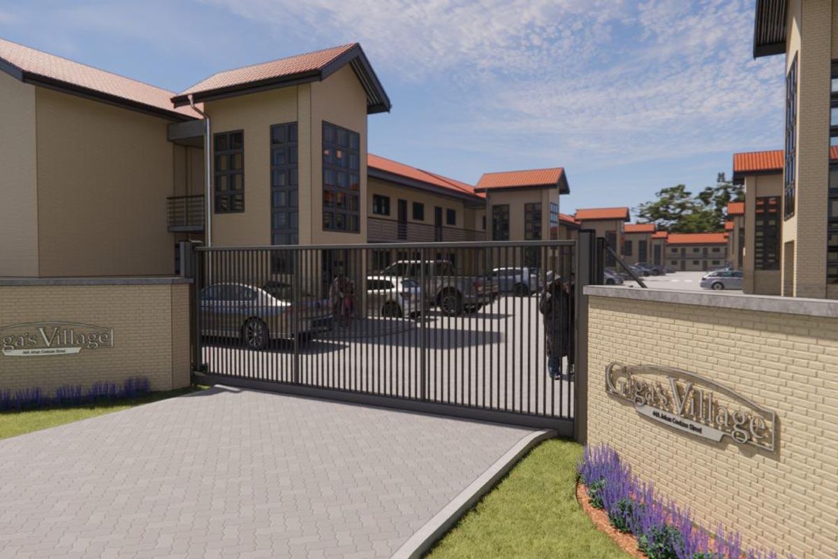 Front entrance view of Giga's Village apartment complex, featuring a secure gated access point, paved driveway, and modern multi-story residential buildings.