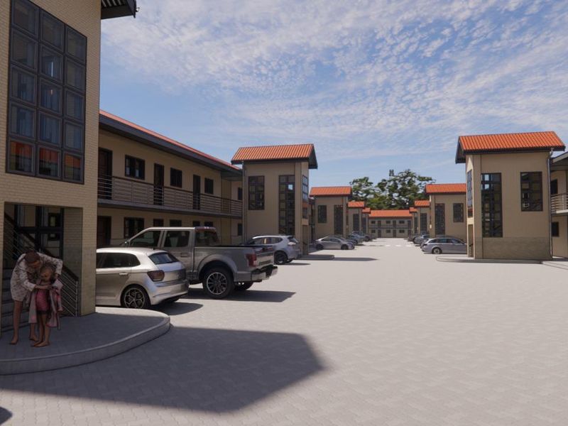 A view of a modern apartment complex featuring paved parking areas and multi-story residential buildings with tiled roofs.
