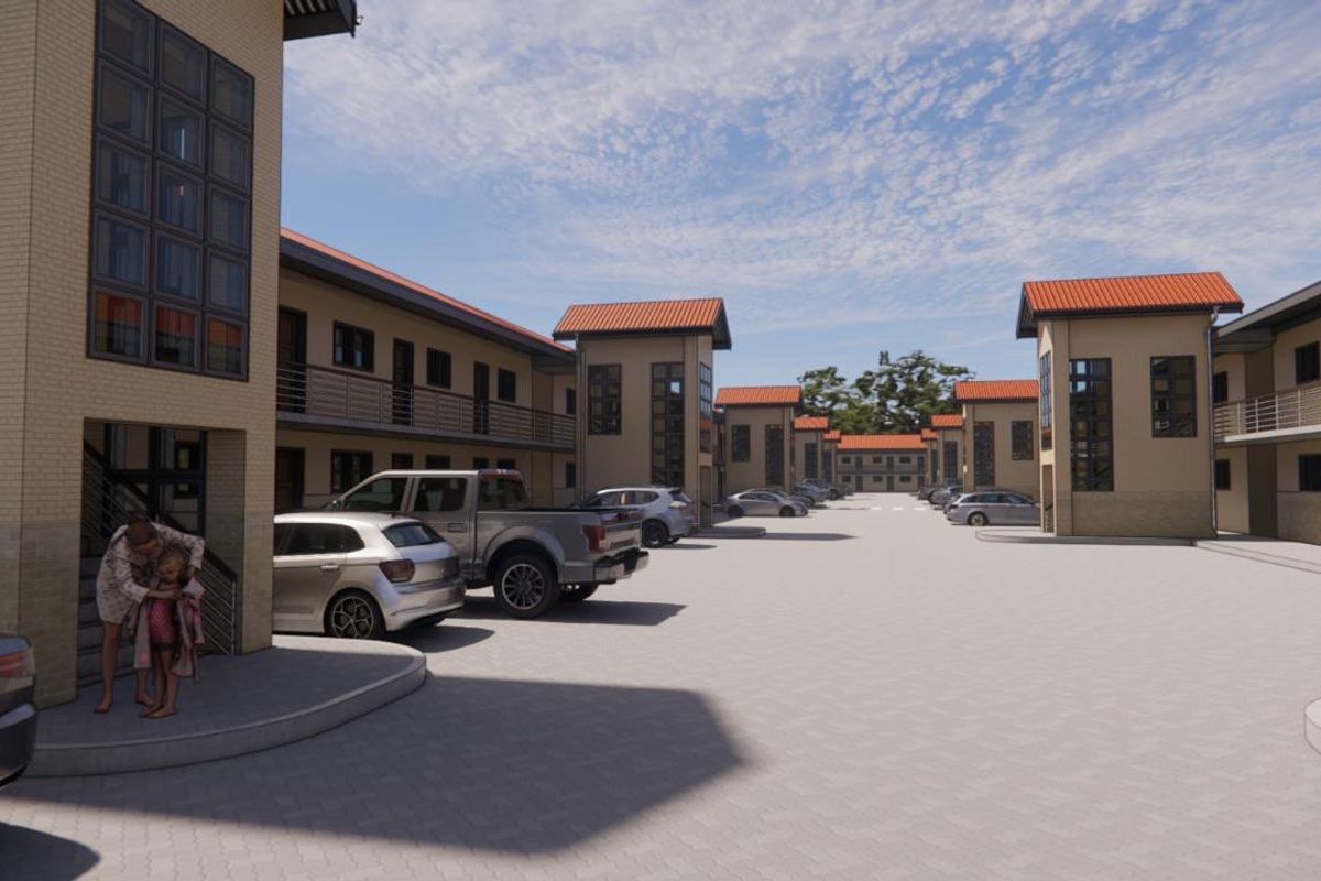 A view of a modern apartment complex featuring paved parking areas and multi-story residential buildings with tiled roofs.