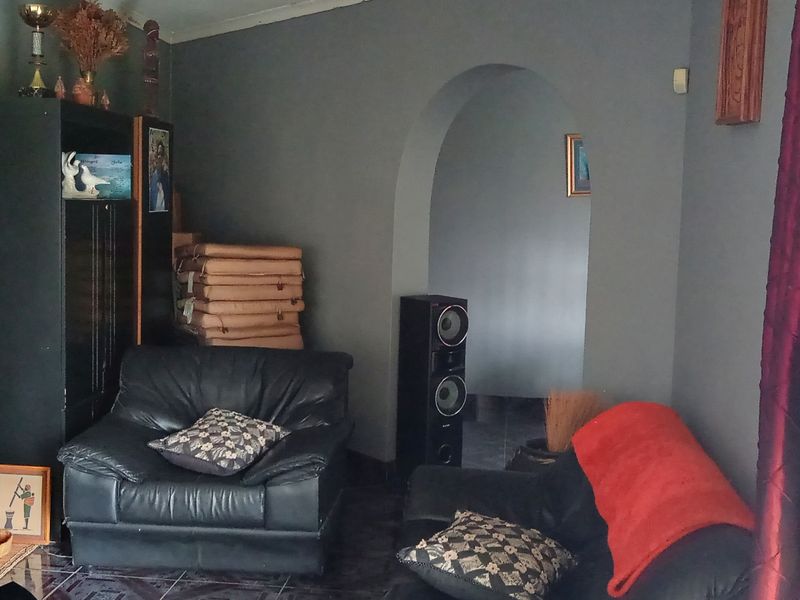 A living room featuring a stone-clad fireplace feature wall and an arched doorway leading to an adjacent space.
