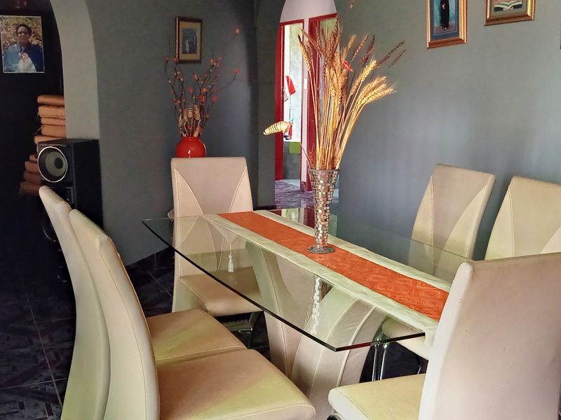 A dining area featuring tiled flooring and arched architectural transitions leading to adjacent spaces.