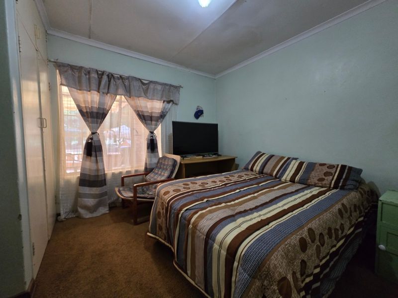 A bedroom featuring built-in wardrobe storage, carpeted flooring, and coved ceiling details, offering a functional space ready for cosmetic updates.