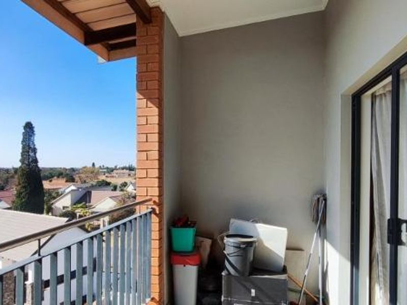 A private balcony featuring a metal balustrade and sliding glass door access, offering elevated views of the surrounding residential neighborhood.