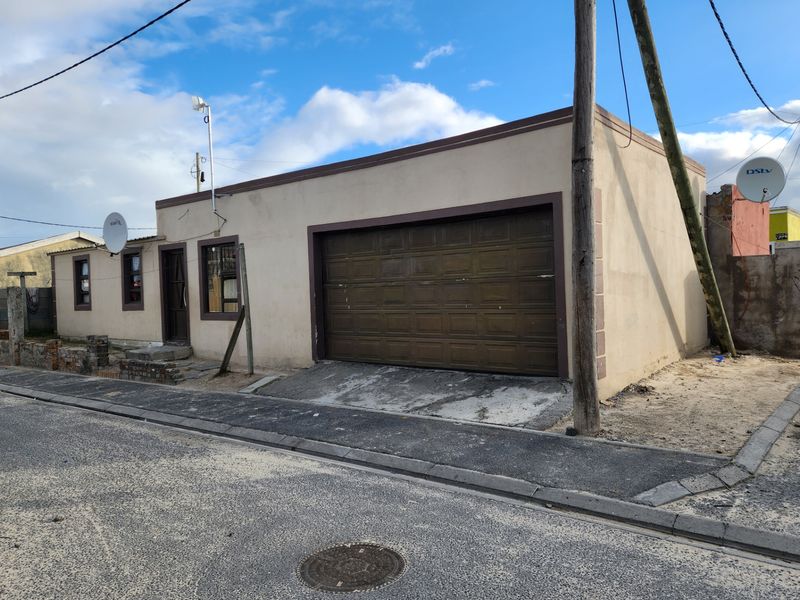 Street-facing view of a residential property featuring a single garage, concrete driveway, and exterior wall finishes.