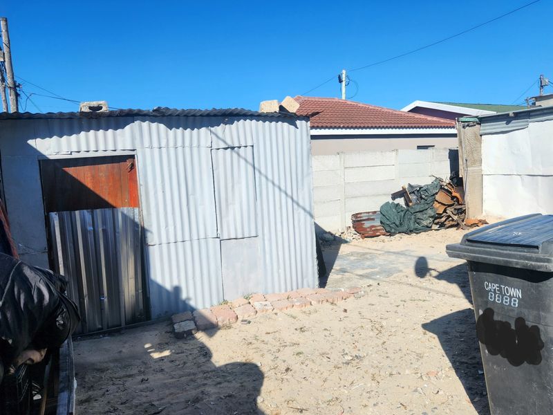 Rear yard area featuring a corrugated iron structure and precast concrete boundary walling.