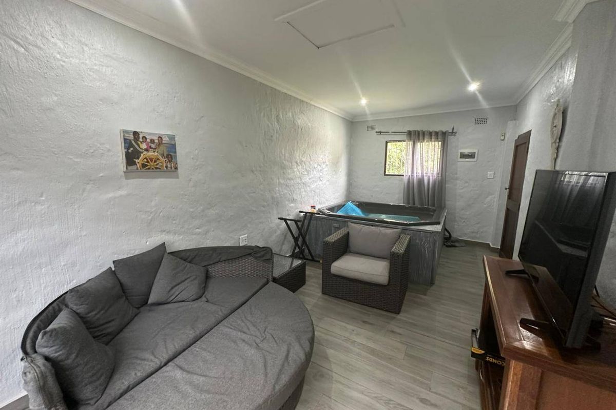 A living area featuring textured walls, laminate flooring, and a built-in indoor jacuzzi, offering a unique relaxation space.