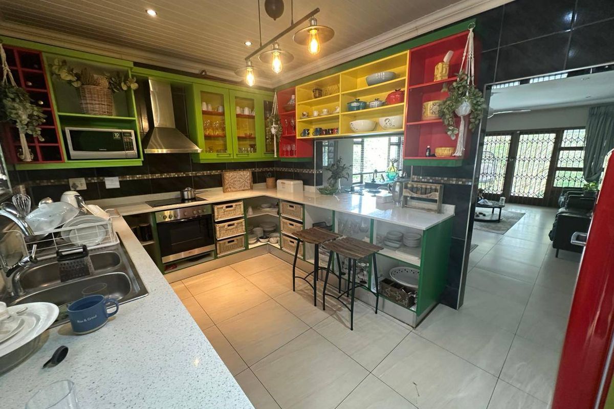 A vibrant kitchen featuring colorful cabinetry, stone countertops, built-in appliances, and tiled flooring, offering a functional and unique culinary space.