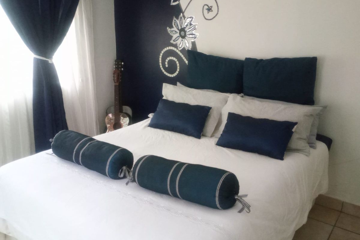 A bedroom featuring tiled flooring and a decorative accent wall.