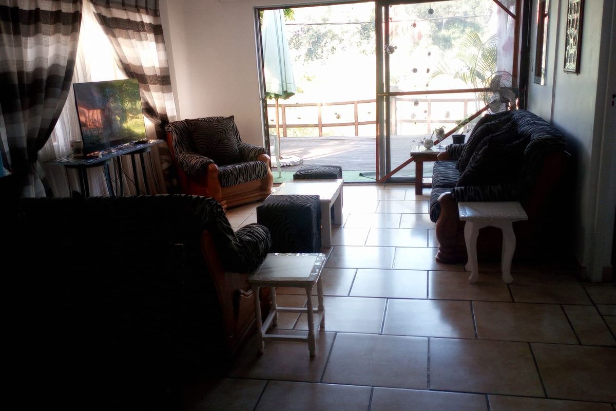 A living room featuring tiled flooring and a large sliding glass door providing direct access to an outdoor deck area.