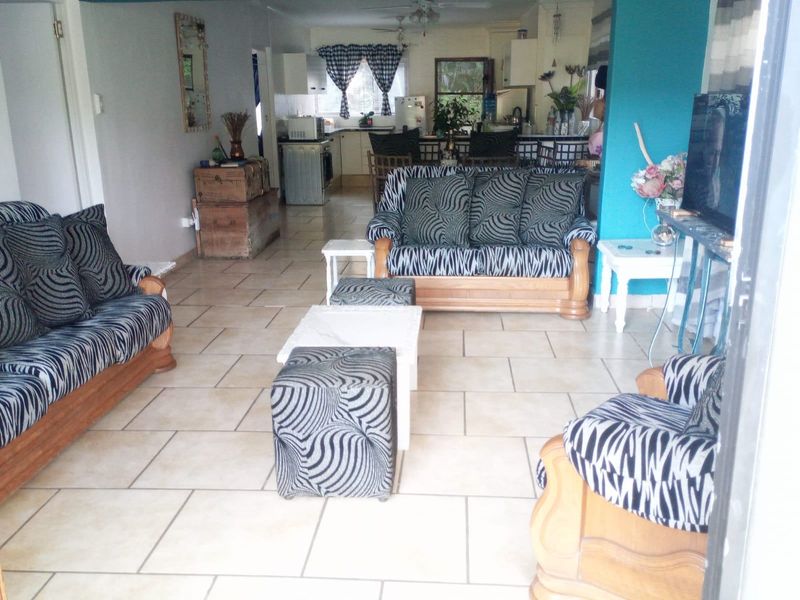 Open plan living and kitchen area featuring ceramic floor tiles and functional kitchen cabinetry.