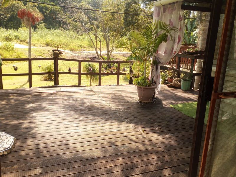 An outdoor timber deck featuring a wooden balustrade, offering an open view of the surrounding garden and natural landscape.