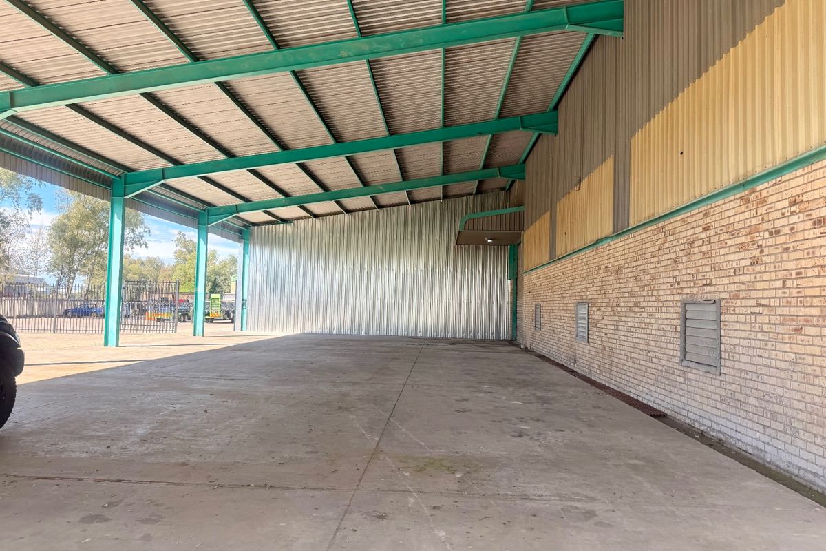 Spacious open-plan utility or storage area featuring a steel portal frame structure, corrugated metal cladding, and durable concrete flooring.