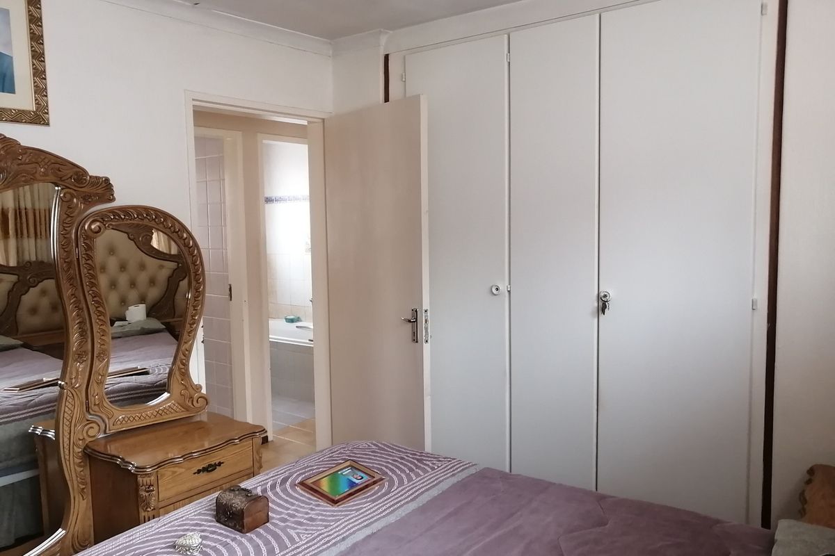 A bedroom featuring built-in cupboards and direct access to an en-suite bathroom.
