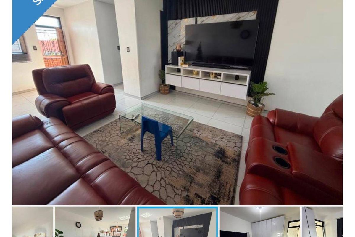 A living room featuring tiled flooring and a modern feature wall with a floating media console.