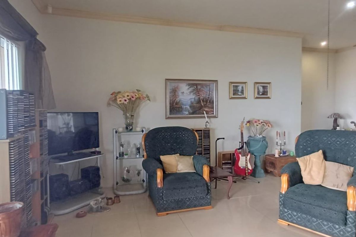 Spacious living area featuring neutral tiled flooring, recessed lighting, a ceiling fan, and large sliding glass doors providing natural light.