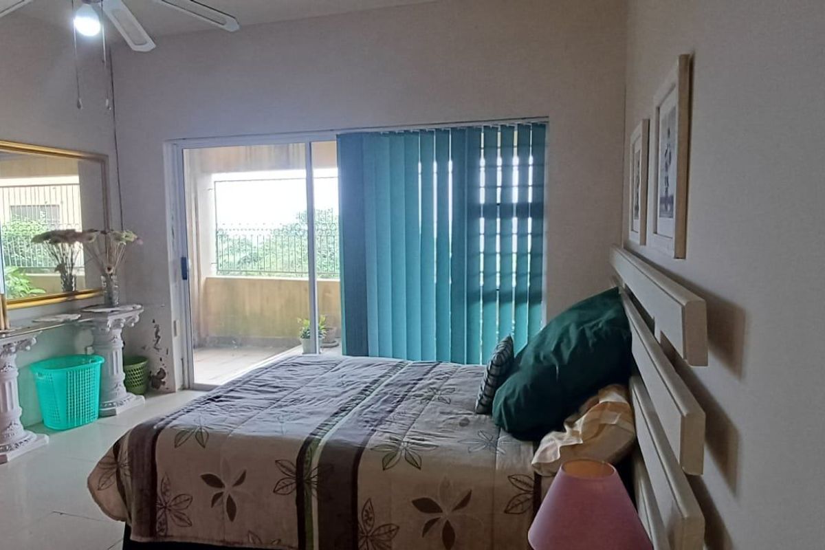 A bedroom featuring tiled flooring, a ceiling fan, and a sliding glass door providing access to an outdoor balcony area.