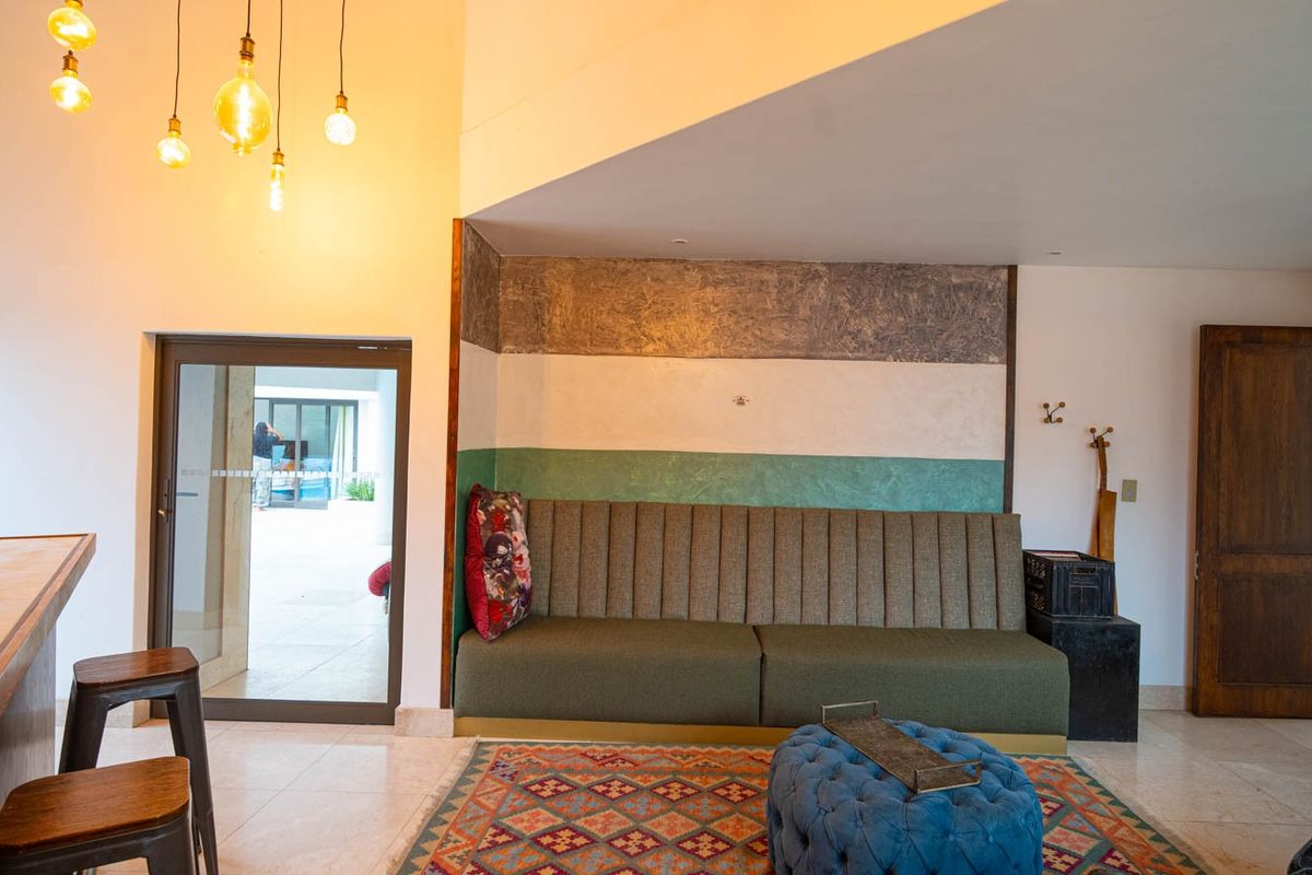 A living area featuring built-in bench seating, tiled flooring, and a glass sliding door providing access to the outdoor patio area.