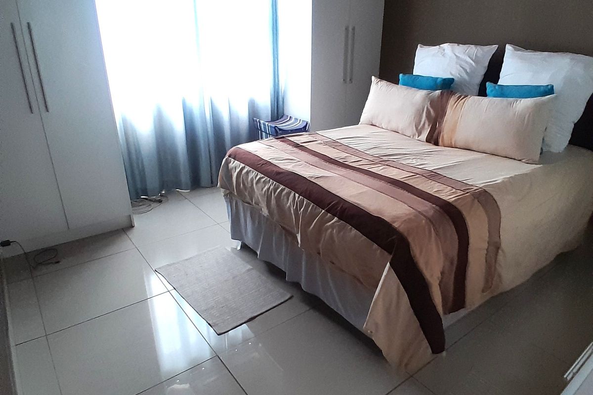 A bedroom featuring tiled flooring and built-in cupboards, providing functional storage space.