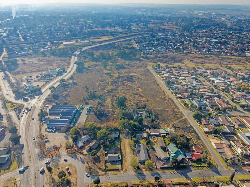 Aerial view of a large vacant residential land parcel situated within an established suburban neighborhood with existing road access and surrounding infrastructure.
