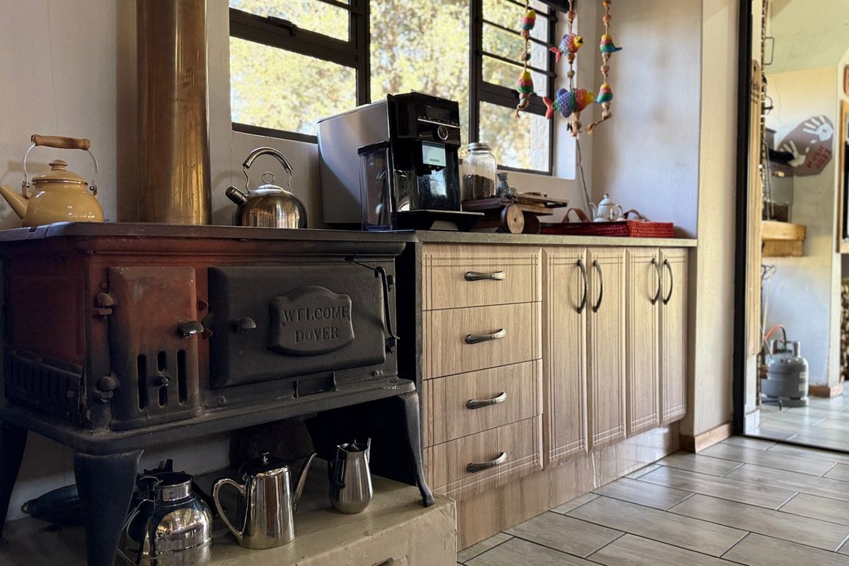A rustic kitchen area featuring a vintage Dover cast-iron stove, wood-look cabinetry, and tiled flooring, creating a warm and functional cooking space.