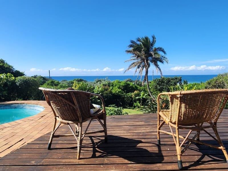 Outdoor pool area featuring timber decking and a swimming pool with scenic ocean views.