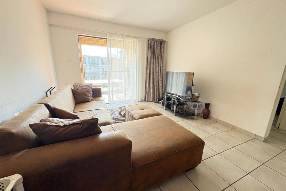 A living room featuring tiled flooring and a sliding glass door providing access to an outdoor area.